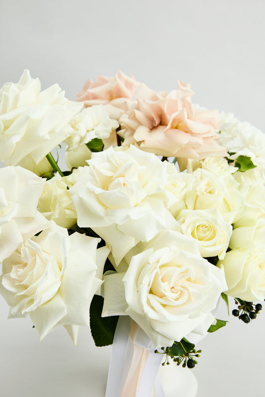 Close up of whispering Romance Bouquet of white and pink flowers in a white vase by flowerdose.