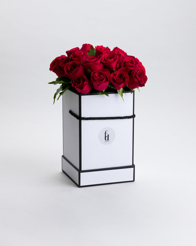 Box Me Up Lover features red roses with green leaves, neatly arranged and presented against a white background.